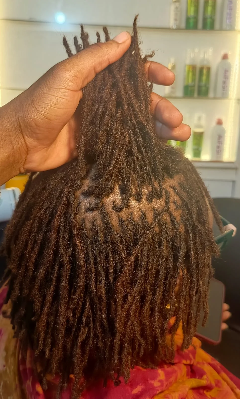 Close view of loc roots and sectioning during hair care, supplied by NBD