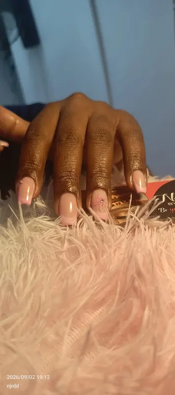 Soft pink square French tips with a flower accent, supplied by NBD
