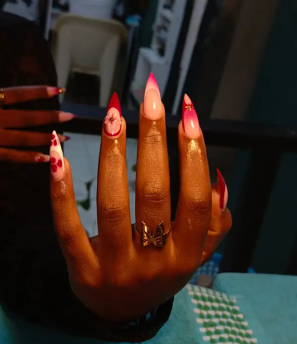 Pink pointed nails with raised floral details and gold accents, supplied by NBD